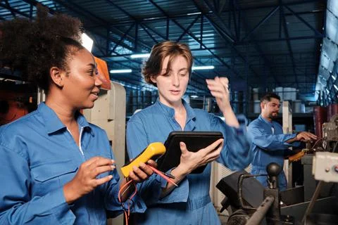 Two professional female engineer workers in safety uniforms work by inspectin Stock Photos