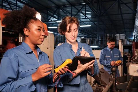 Two professional female engineer workers in safety uniforms work by inspectin Stock Photos