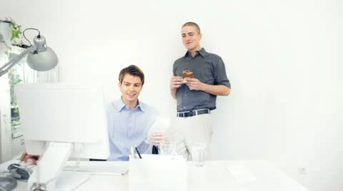 Two professional male IT tech staff working at lunch time in an office desk Stock Footage 22245205