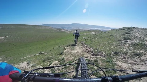 Two Professional Mountain Bikers Riding Through Grasslands On A Sunny Day Vídeo Stock 101498355