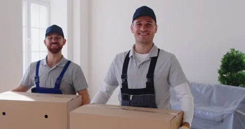 Two professional movers delivering and unloading cardboard boxes during Stock Footage 327610441