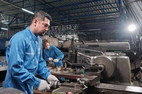 Two professional workers team working in the metalwork manufacturing factory. Stock Photos