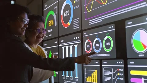 Two professionals analyze data on a large touchscreen, pointing at colorful.. Stock Footage 326727073