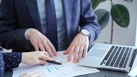 Two professionals analyzing a pie chart during a strategic business meeting Stock Photos