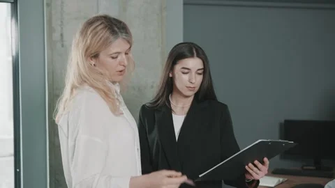 Two professionals collaborate in an office setting while reviewing documents Video stock 312260022