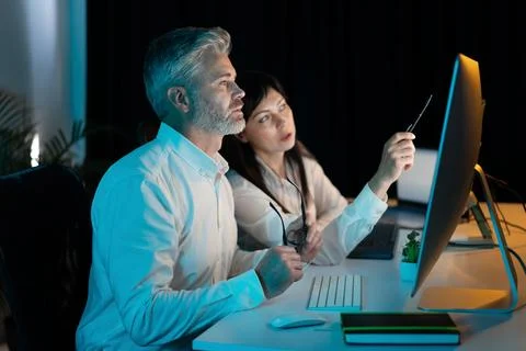 Two Professionals Collaborating on Computer in Modern Office Setting Stock Photos