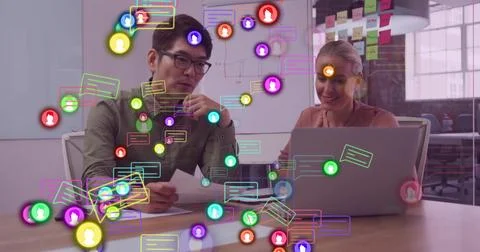 Two professionals collaborating at office table, reviewing report with laptop Stock Photos
