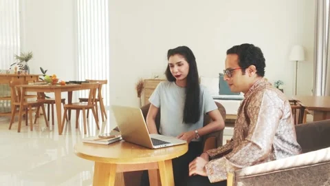 Two professionals discussing work on a laptop in a modern home office. Stock-Footage 302350432