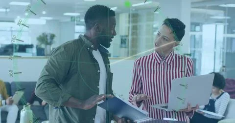 Two professionals discussing work over document folder and laptop in open plan Stock Photos