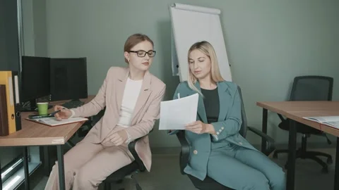 Two professionals engage in a focused discussion while reviewing documents Stock Footage 310556240