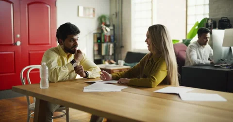 Two professionals go over notes at meeting in modern well lit office during the Video stock 199462868