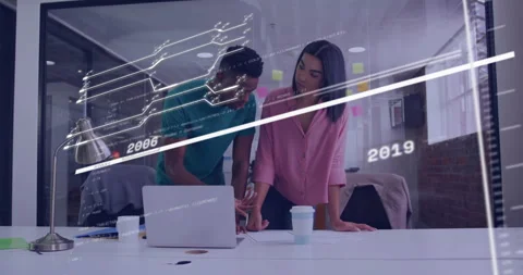 Two professionals leaning over desk in tech office space, reviewing code and Stock Footage 307432386