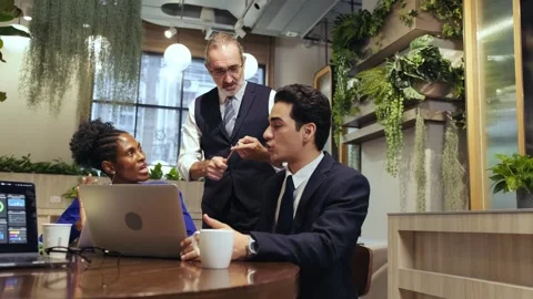Two professionals meet in a modern cafe, discussing work at a laptop Stock Footage 317668934
