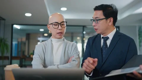 Two professionals review documents together at a desk Видео 346681598