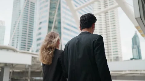 Two professionals walk together through a modern cityscape Vídeo Stock 345198453