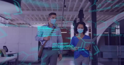 Two professionals walking through tech office, reviewing laptop amid code and Stock Footage 307974233