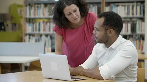 Two professors discussing new academic plan at library. Stock Footage 116775978