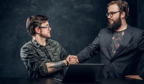 Two programmer's colleagues shake hands after completion of the general project Stock Photos