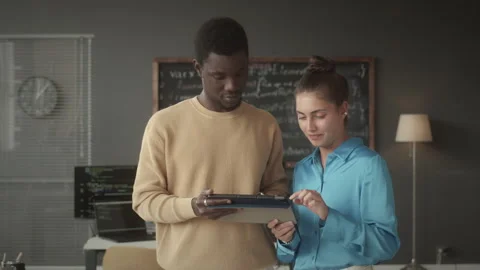 Two Programmers Discussing Data on Digital Tablet in Office Video stock 263728772