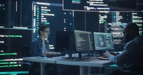 Two Programmers Writing Code Surrounded by Big Screens Stock Footage 243287818