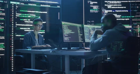 Two Programmers Writing Code Surrounded by Big Screens Stock Footage 243287945
