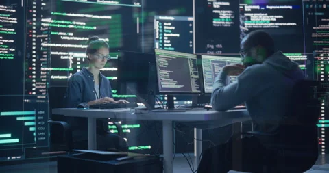 Two Programmers Writing Code Surrounded by Big Screens Stock Footage 243288002