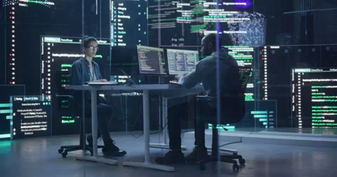 Two Programmers Writing Code Surrounded by Big Screens Stock Footage 243288180