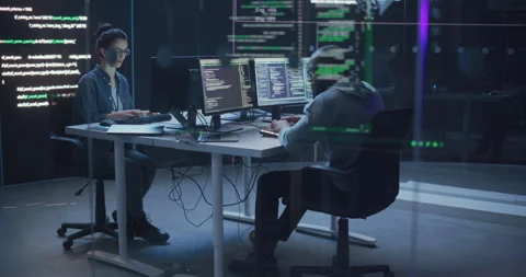 Two Programmers Writing Code Surrounded by Big Screens Stock Footage 243288263