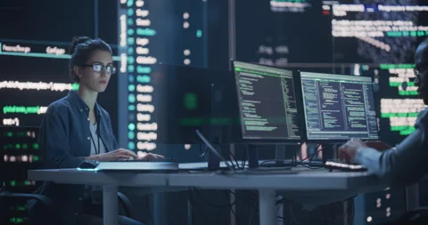 Two Programmers Writing Code Surrounded by Big Screens Stock Footage 243288351