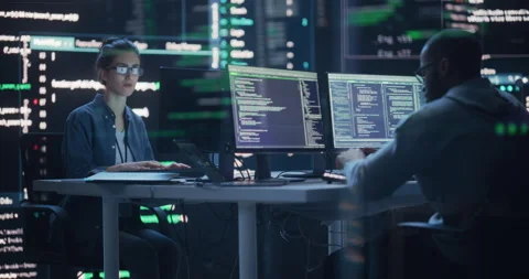 Two Programmers Writing Code Surrounded by Big Screens Stock Footage 243288370