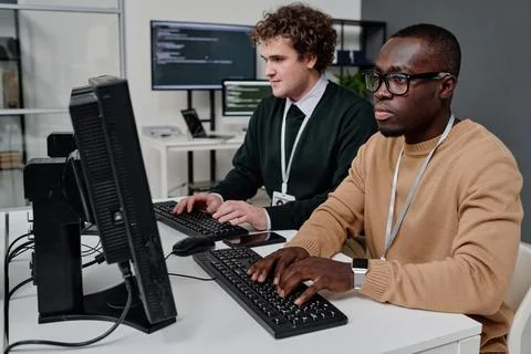 Two programmers writing security code on computers Stock Photos
