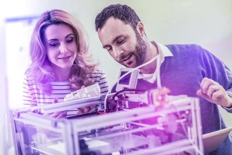 Two progressive programmers fond of digitalization standing near big device Stock-Fotos