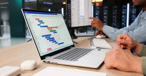 Two Project Managers Discuss Schedules And Track Progress Using Gantt Charts. Stock Photos