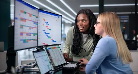 Two Project Managers Plan Team Tasks Using A Digital Gantt Chart Together. Stock Photos