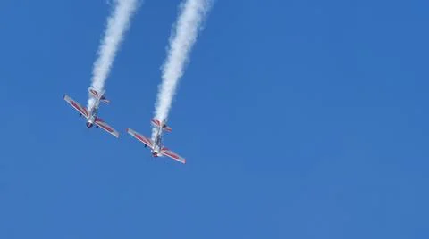 Two propeller planes do a looping with white smoke in the blue sky. Copy space Foto stock