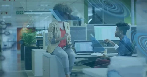 Two pros discussing business data on laptop, one pointing, sparking tablet Stock Footage 321070691