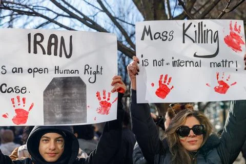 Two protesters hold signs reading "IRAN is an open Human Right Case" and "M.. Stock Photos
