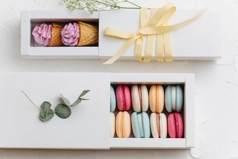 Two pull out boxes with sweets. Macarons and waffle cones with zefir on top Foto stock