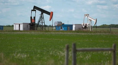 Two pump jacks working in the prairies Video stock 67612638