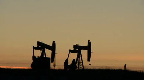 Two pumpjacks pumping crude oil at dusk Video stock 44614237