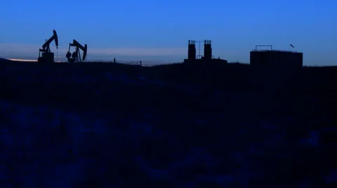 Two pumpjacks pumping crude oil at dusk Stock Footage 44615064