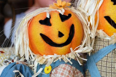 Two pumpkin head scarecrow on display next to a babys portrait Stock Photos