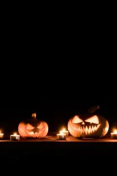 Two pumpkins are on the table, and candles are burning around. Halloween art  Foto stock
