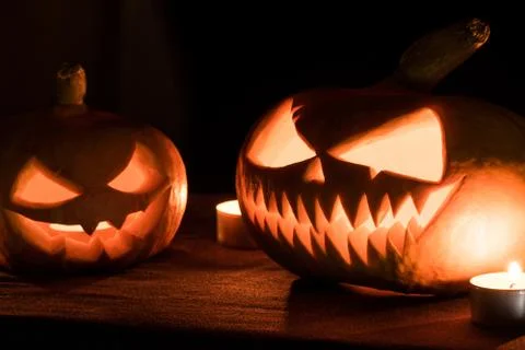 Two pumpkins are on the table, and candles are burning around. Halloween art  Foto stock