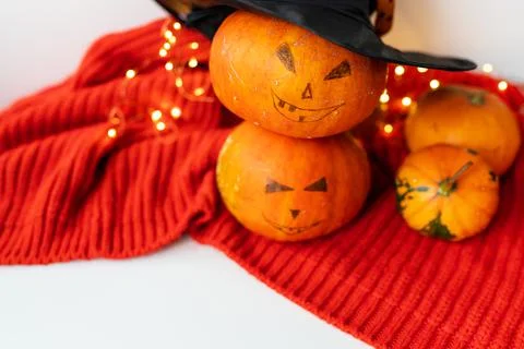 Two pumpkins with a painted face on a red sweater. Holiday concept of October Stock Photos