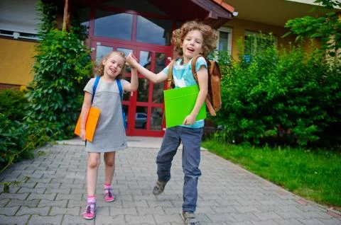 Two pupils of elementary school, boy and girl, on a schoolyard. Stock Photos