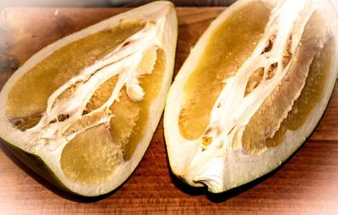 Two quarters of pomelo fruit sliced on a wooden board. Stock Photos