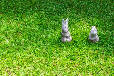 Two rabbit statue on green grass Stock Photos