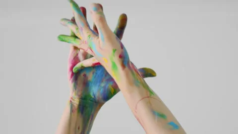 Two raised hands painted in different colors gently touch each other Stock Footage 158631725