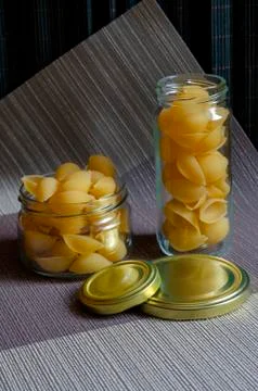Two random glass jars of raw Conchiglie. Stock Photos